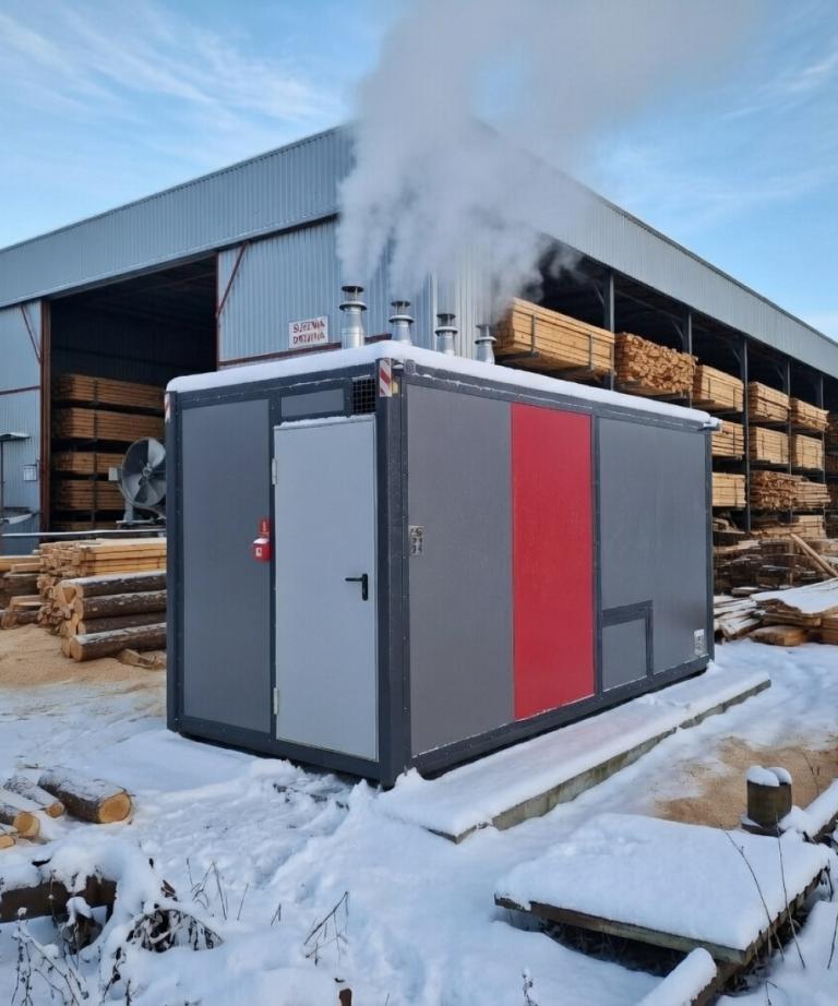 Mobilna kotłownia gazowa 480 kW marki Plomex-Pol na zdjęciu. Gotowy system ogrzewania w kontenerze, zasilany gazem, idealny dla obiektów przemysłowych, takich jak tartaki lub hale produkcyjne.